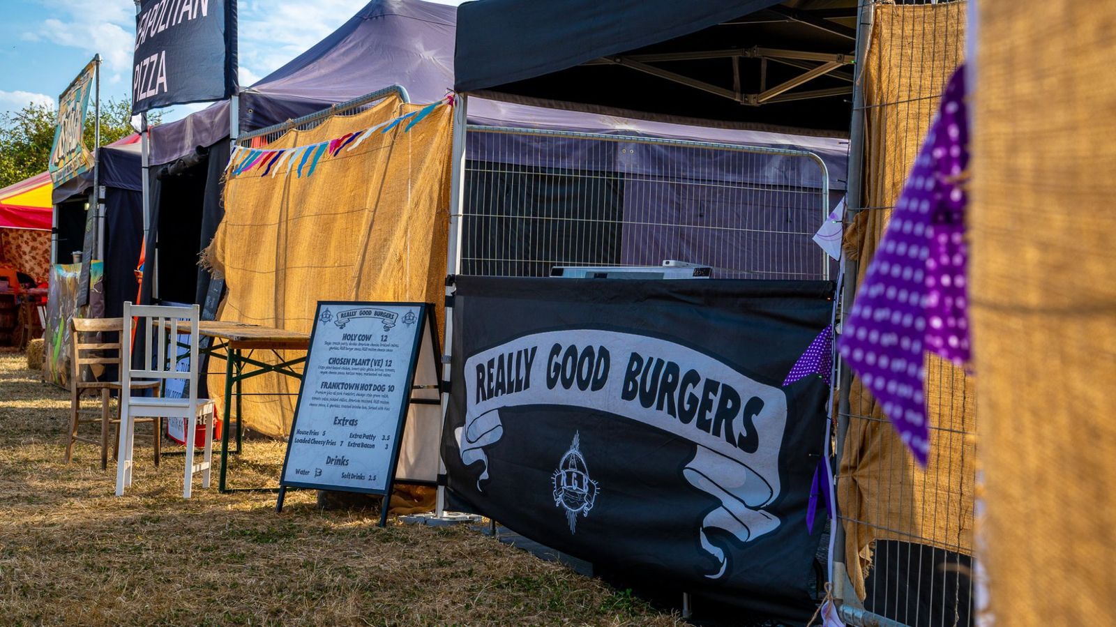 Really Good Burgers stall and menu board in a festival food row