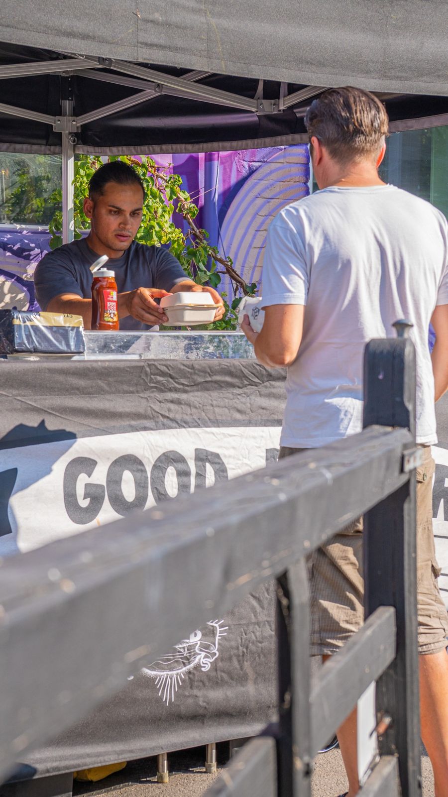 Really Good Burgers chef handing a boxed burger to a customer